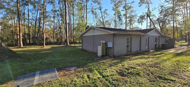 view of side of property featuring a lawn and fence