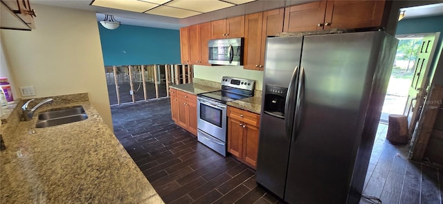 6906 Quail Hollow Blvd, Wesley Chapel, FL 33544 - kitchen featuring stainless steel appliances, a sink, dark wood-style floors, brown cabinetry, and light stone countertops