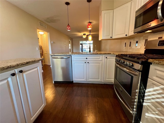 kitchen with white cabinets, sink, dark hardwood / wood-style floors, appliances with stainless steel finishes, and light stone counters