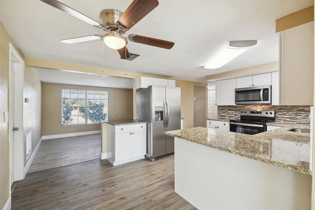 kitchen featuring white cabinetry, light wood-type flooring, kitchen peninsula, and appliances with stainless steel finishes