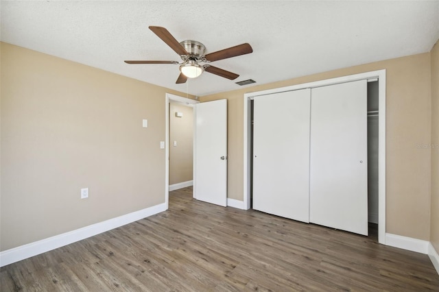 unfurnished bedroom featuring hardwood / wood-style floors, a textured ceiling, a closet, and ceiling fan