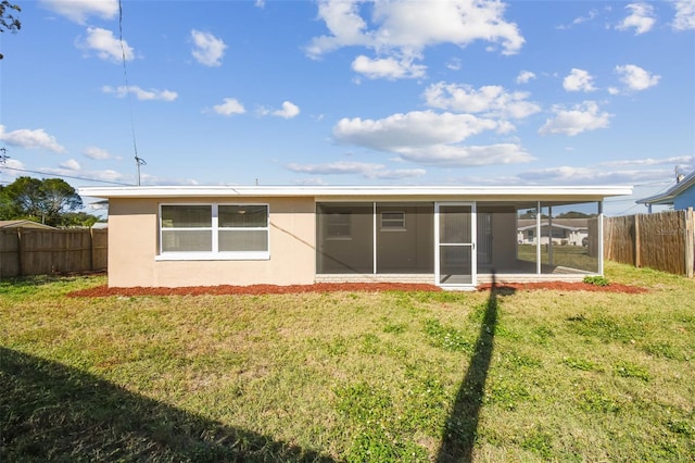 back of property with a sunroom and a yard