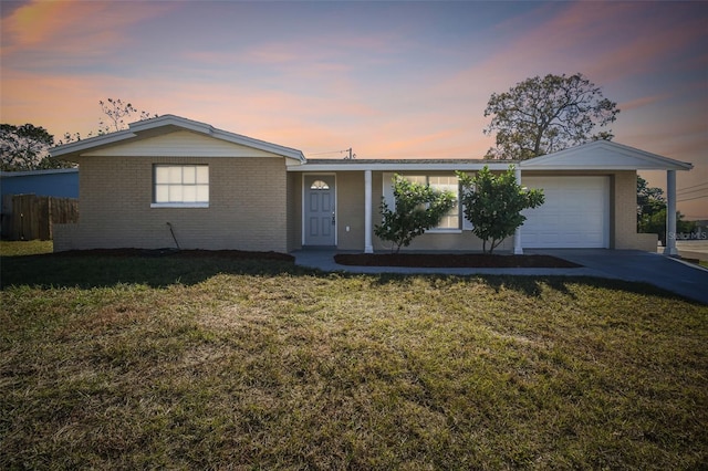 single story home with a garage and a yard