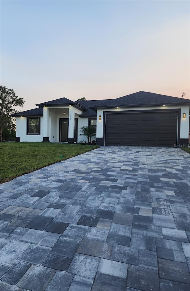 view of front of home with a yard and a garage