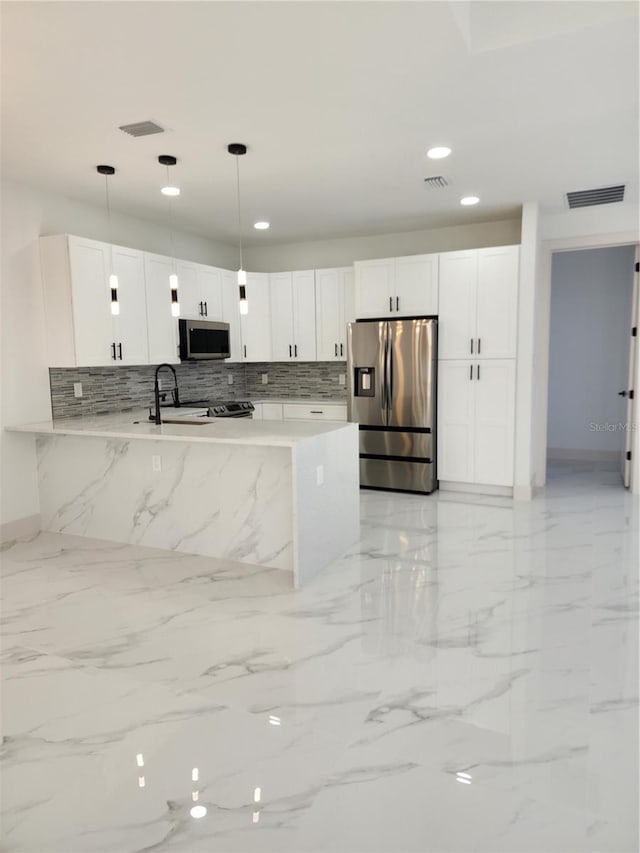 kitchen with white cabinetry, tasteful backsplash, kitchen peninsula, decorative light fixtures, and appliances with stainless steel finishes