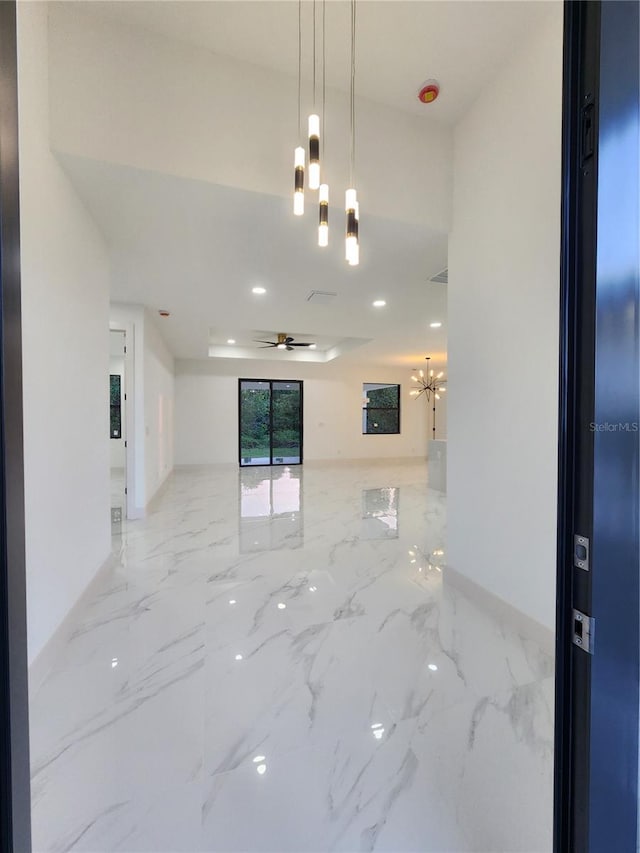 spare room with ceiling fan with notable chandelier