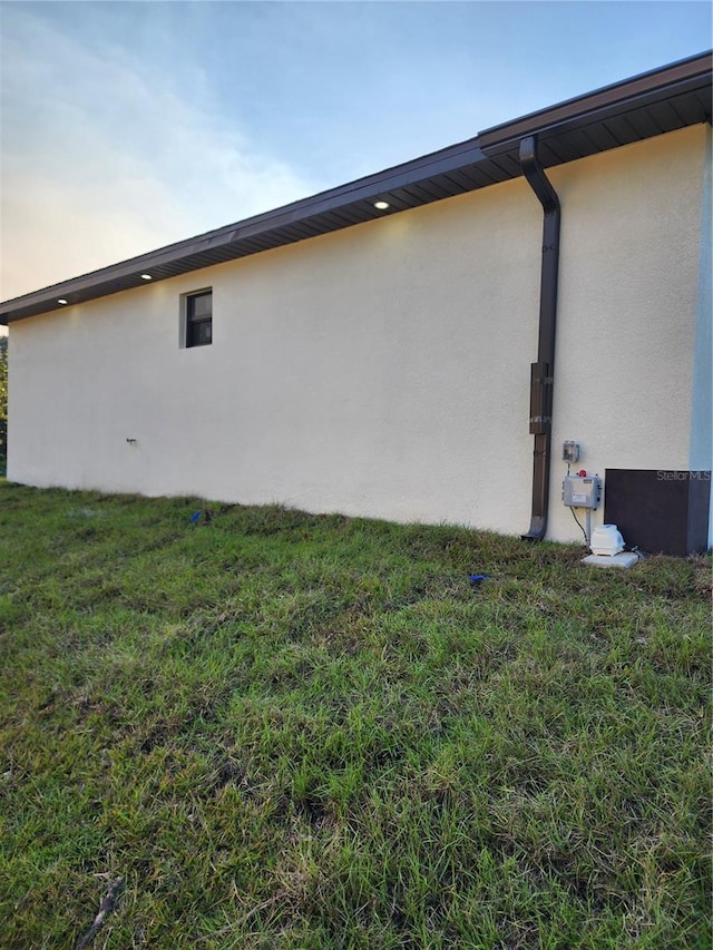 property exterior at dusk with a yard