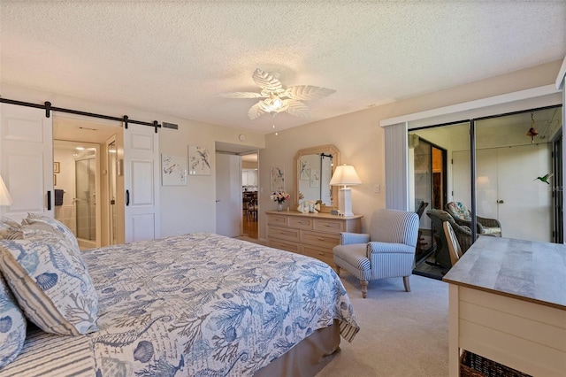 bedroom featuring a barn door, ceiling fan, light carpet, and a textured ceiling