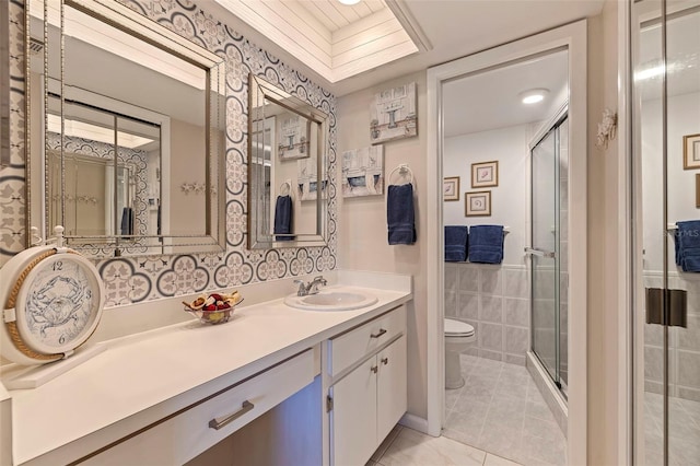 bathroom featuring vanity, toilet, walk in shower, and tile walls