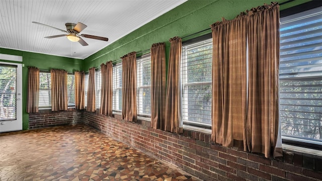 unfurnished sunroom featuring ceiling fan