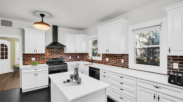 kitchen with white cabinets, sink, wall chimney exhaust hood, and black appliances