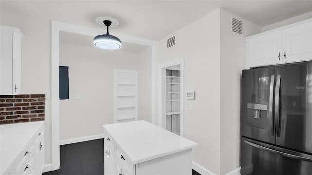 kitchen featuring pendant lighting, white cabinetry, stainless steel fridge with ice dispenser, and dark tile patterned floors