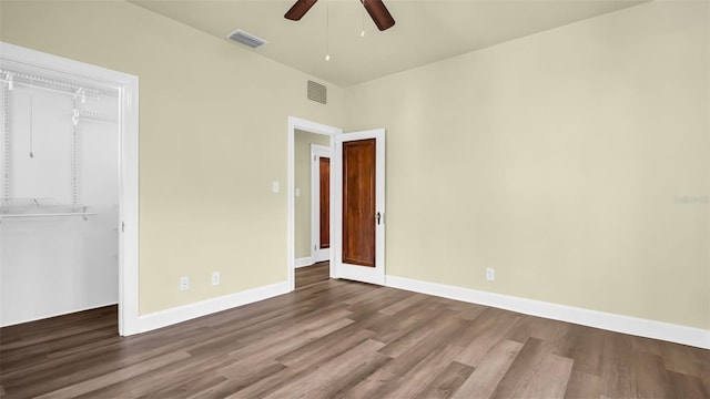 unfurnished bedroom featuring hardwood / wood-style floors, ceiling fan, and a closet