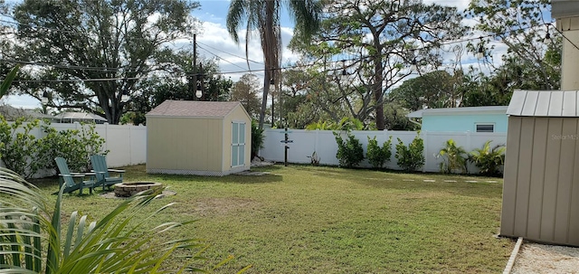 view of yard featuring a storage shed and an outdoor fire pit