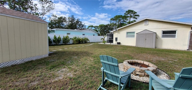 view of yard with a shed and a fire pit