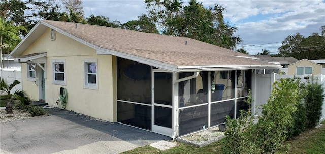 rear view of house featuring a sunroom