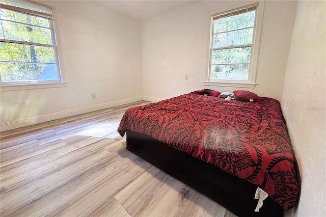 bedroom featuring light hardwood / wood-style flooring and multiple windows