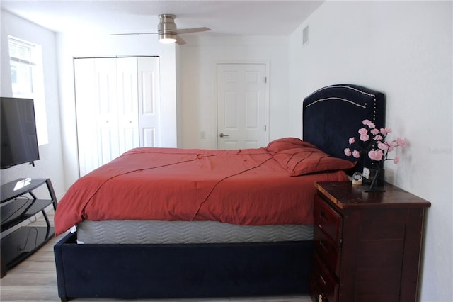 bedroom with light wood-type flooring, a closet, and ceiling fan