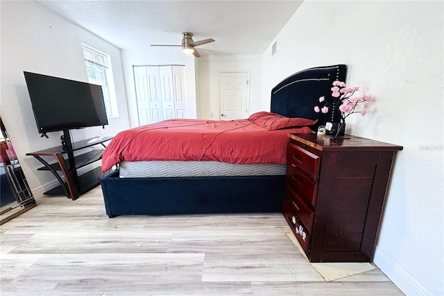 bedroom with ceiling fan, a closet, and light hardwood / wood-style floors