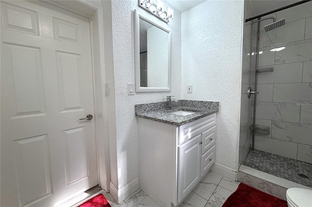 bathroom featuring vanity, toilet, and tiled shower