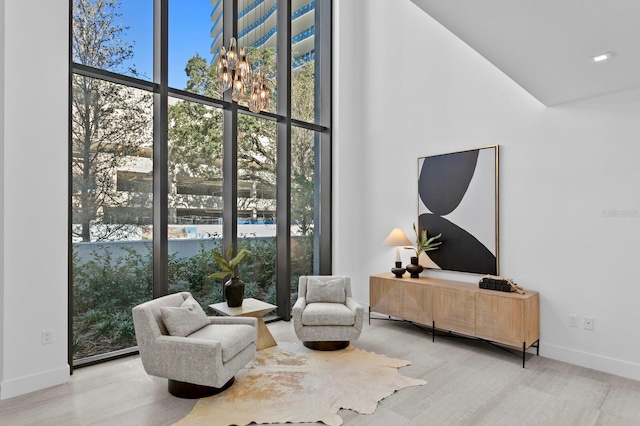 sitting room with hardwood / wood-style flooring and a high ceiling