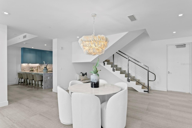 dining space with sink and a notable chandelier