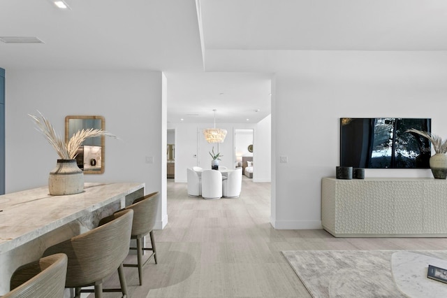 dining area featuring light hardwood / wood-style floors and a notable chandelier