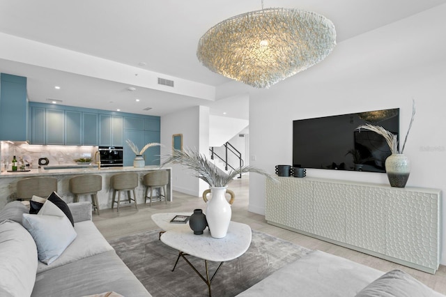 living room featuring light hardwood / wood-style flooring and a notable chandelier