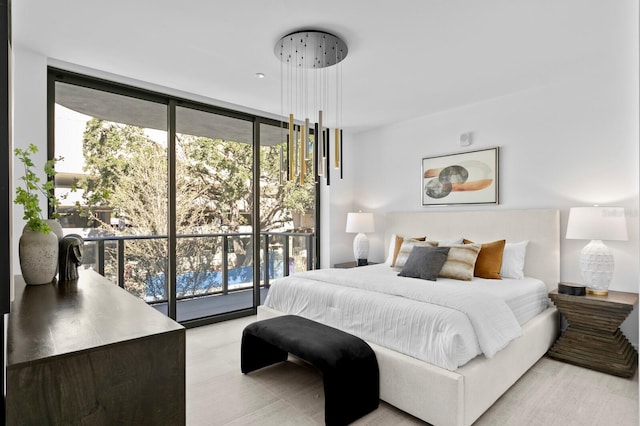 bedroom featuring expansive windows, access to outside, multiple windows, and light hardwood / wood-style floors