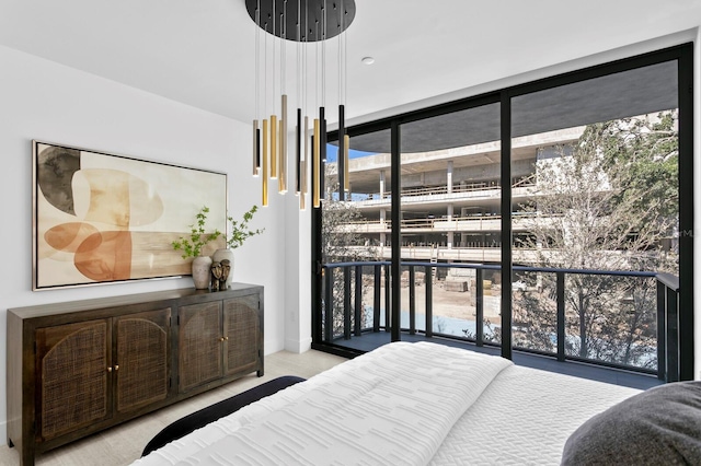 carpeted bedroom featuring access to exterior and a wall of windows