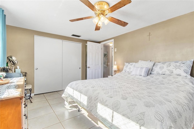 bedroom with a closet, ceiling fan, and light tile patterned flooring