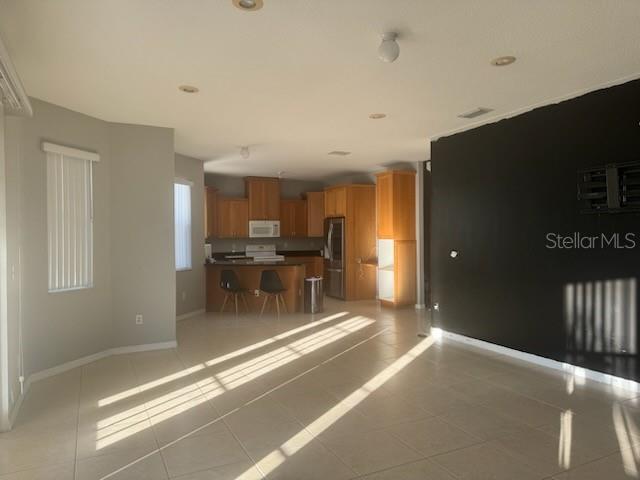 4015 Woodacre Ln, Tampa, FL 33624 - living room featuring light tile patterned flooring and baseboards