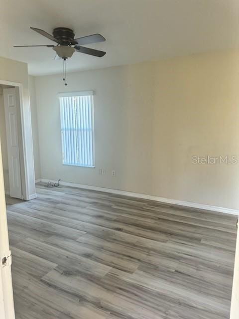 empty room with light wood-type flooring and ceiling fan