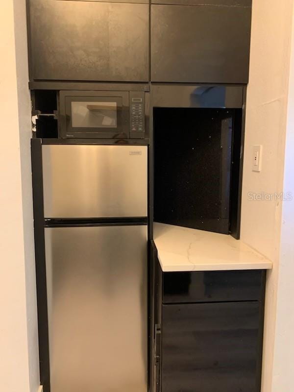 4015 Woodacre Ln, Tampa, FL 33624 - detailed view of freestanding refrigerator and black microwave