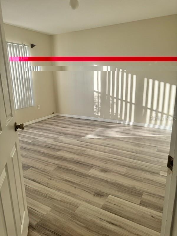 4015 Woodacre Ln, Tampa, FL 33624 - spare room with wood finished floors and baseboards