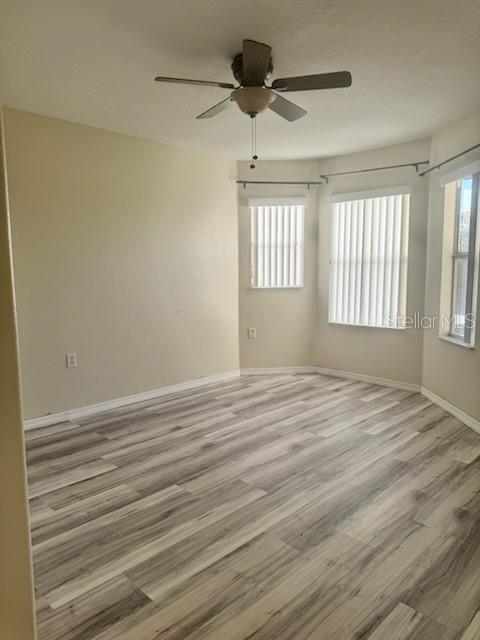 4015 Woodacre Ln, Tampa, FL 33624 - empty room featuring wood finished floors, baseboards, and ceiling fan