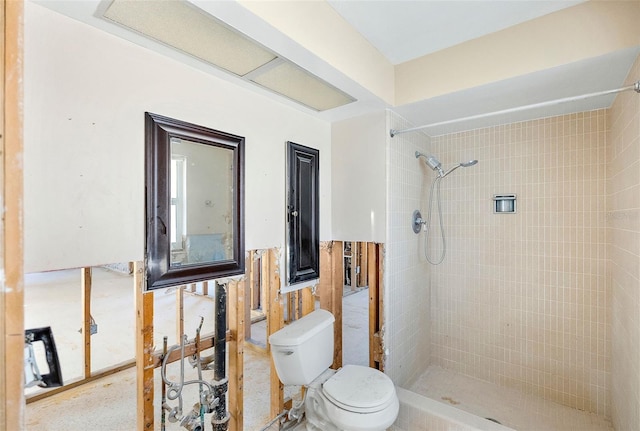 bathroom featuring a tile shower and toilet