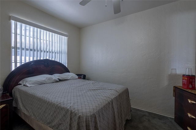 bedroom with ceiling fan and dark carpet