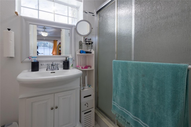 bathroom with ceiling fan, a shower with door, and vanity