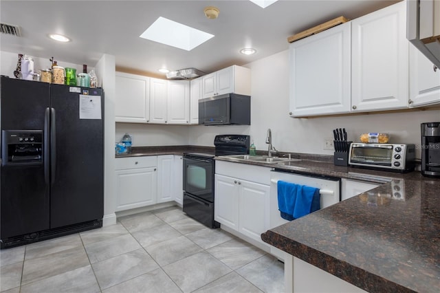 kitchen with sink, a skylight, white cabinetry, and black appliances