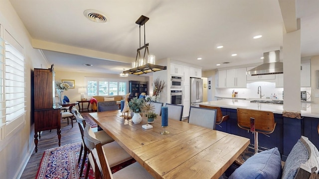 dining area with a barn door and wood-type flooring