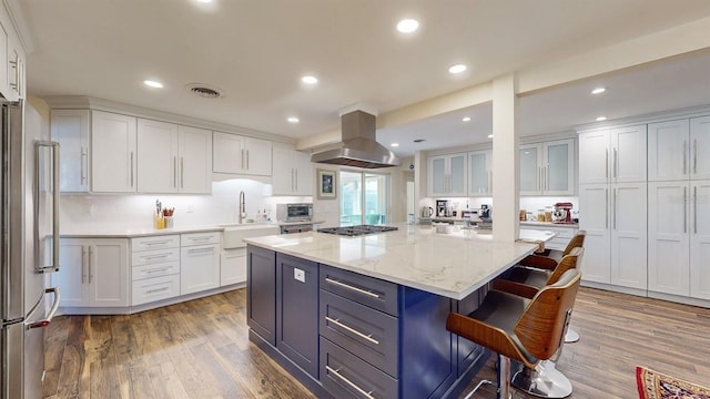 kitchen featuring island exhaust hood, a center island, and white cabinets