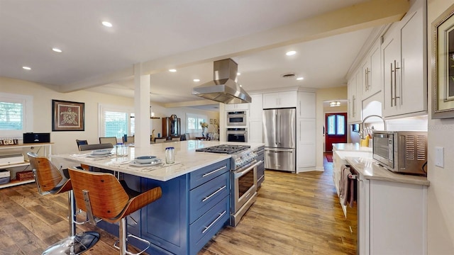 kitchen with a center island, stainless steel appliances, ventilation hood, light hardwood / wood-style floors, and white cabinets