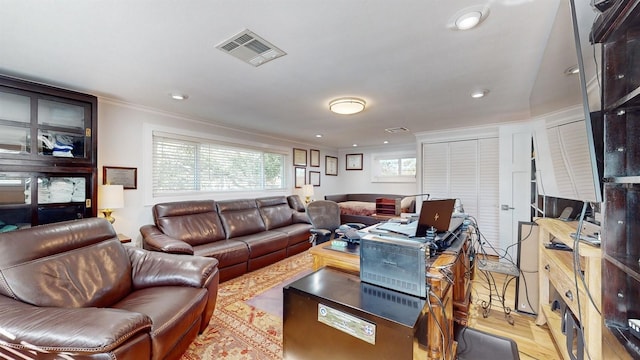 living room featuring light hardwood / wood-style flooring and crown molding