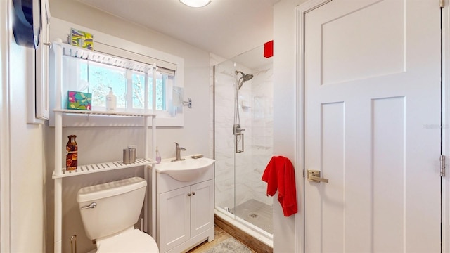 bathroom with vanity, toilet, and a shower with shower door