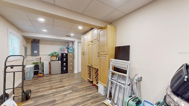 interior space featuring hardwood / wood-style flooring, a paneled ceiling, and electric panel