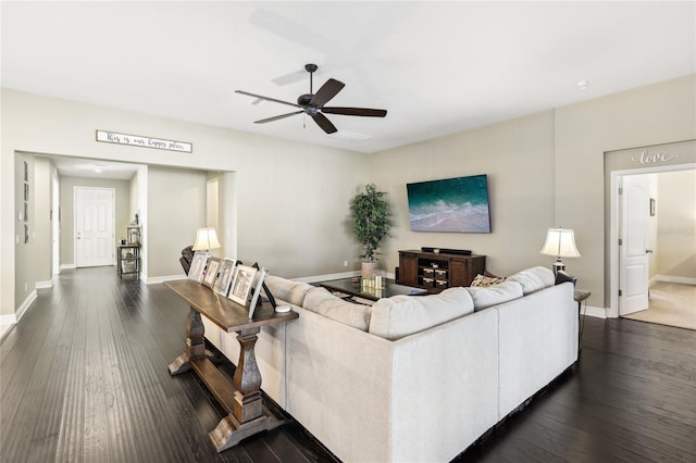 living room featuring ceiling fan and dark wood-type flooring