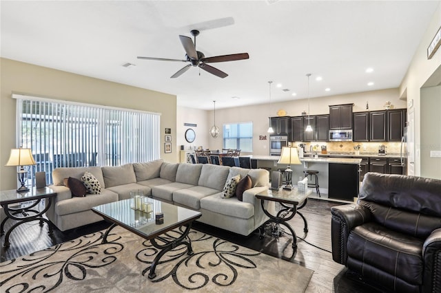 living room with ceiling fan and light hardwood / wood-style flooring