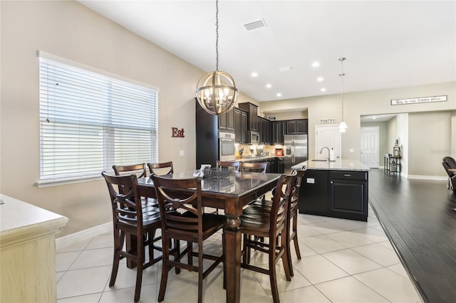 tiled dining area with a notable chandelier and sink