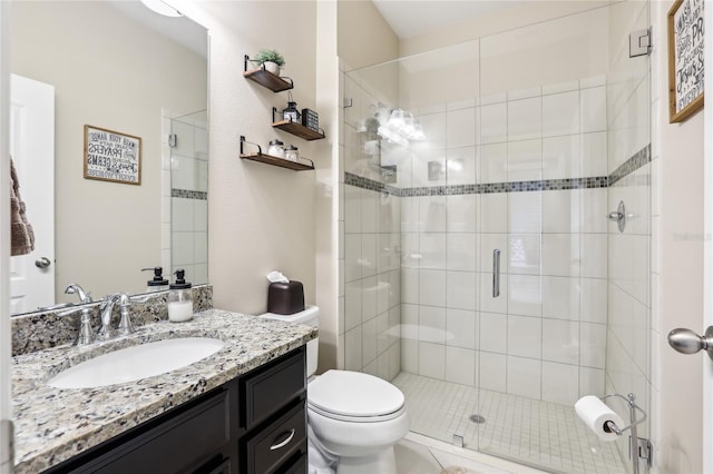 bathroom featuring toilet, a shower with door, and vanity